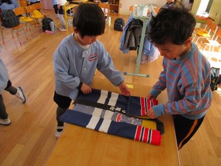 はっぴをたたんでいる子どもたちの写真