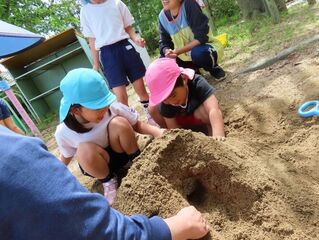 トンネルづくりをしている子どもたちの写真