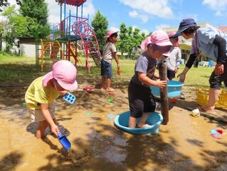 泥遊びをしている子どもたちの写真
