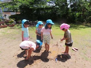 泥遊びをしている子どもたちの写真