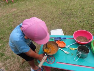 木の実でごちそう作りをしている子どもの写真