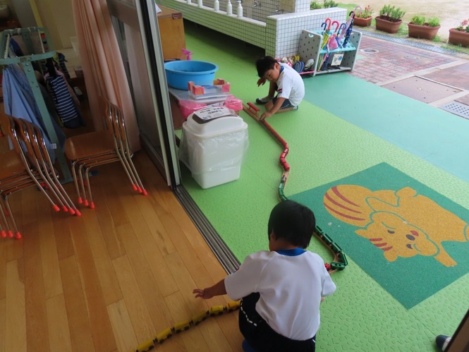 線路をつなげて遊んでいる子どもたちの写真