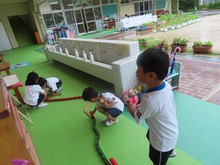 線路をつなげて遊んでいる子どもたちの写真