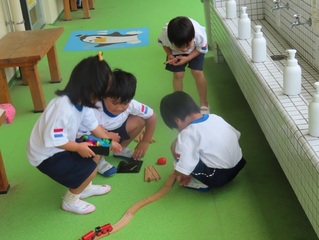 線路をつなげて遊んでいる子どもたちの写真