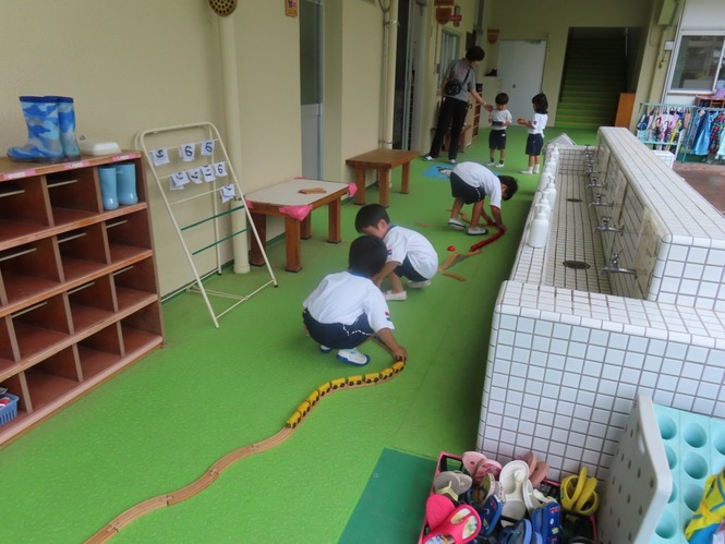 線路をつなげて遊んでいる子どもたちの写真