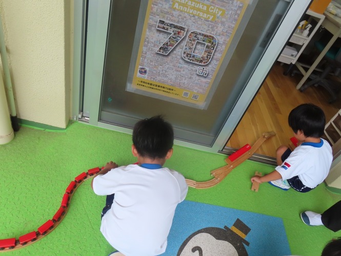線路をつなげて遊んでいる子どもたちの写真