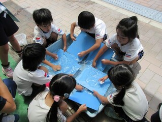 粘土板を洗っている子どもたちの写真