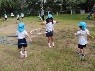 水の輪くぐりをして遊んでいる子どもたちの写真