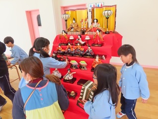 おひなさまを飾っている子どもたちの写真