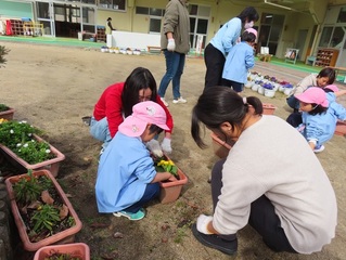 お花を植えている子どもたちの写真