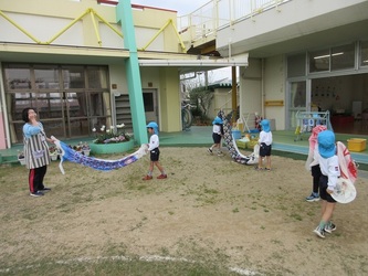 こいのぼりと遊んでいる子どもたちの写真