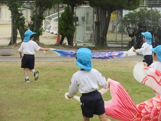 こいのぼりと遊んでいる子どもたちの写真