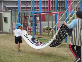 こいのぼりと遊んでいる子どもたちの写真