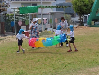 こいのぼりと遊んでいる子どもたちの写真