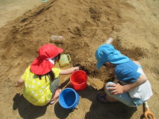 土山で遊んでいる子どもたちの写真