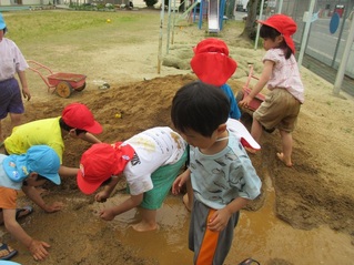 土山で遊んでいる子どもたちの写真