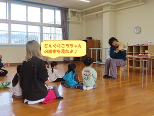 どんぐりの絵本を見ている子どもたちの写真