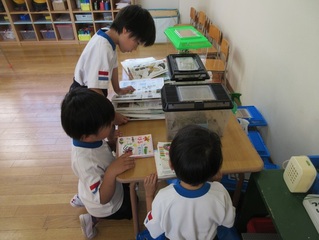 幼虫を見ている子どもたちの写真