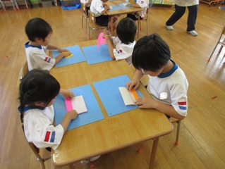 折り紙を折っている子どもたちの写真