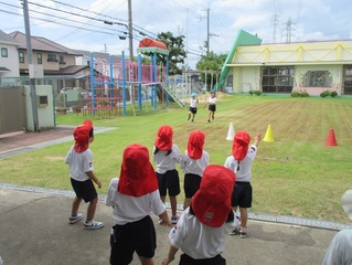 友達を応援している子どもたちの写真