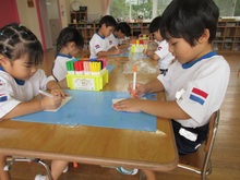 ハガキを描いている子どもたちの写真