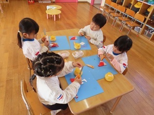 サンタさんたちを作っている子どもたちの写真