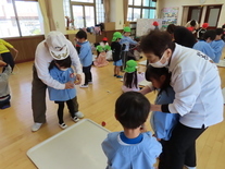 こま回しに挑戦している子どもたちの写真