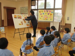 お話のプレゼントを見ている子どもたちの写真