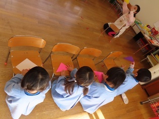 豆を入れるコップを作っている子どもたちの写真