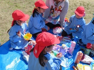 園庭でピクニック弁当をしている子どもたちの写真2