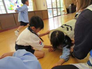 こいのぼりをくぐっている子どもたちの写真