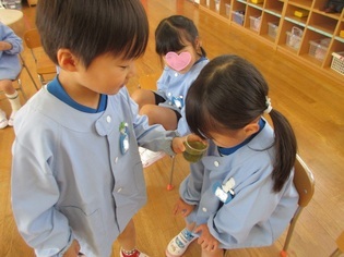 作った色水を見せている子どもたちの写真