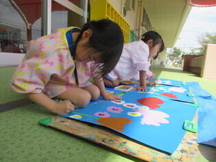 花を描いている子どもたちの写真