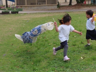 鯉のぼりで遊んでいる子どもたちの写真