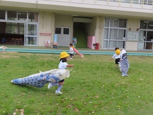 鯉のぼりで遊んでいる子どもたちの写真