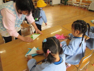 かぶとを折っている子どもたちの写真