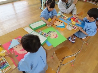 自分の顔を描いている子どもたちの写真