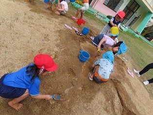 土山で遊んでいる子どもたちの写真