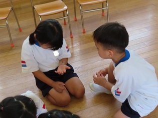 ダンゴムシと遊んでいる子どもたちの写真