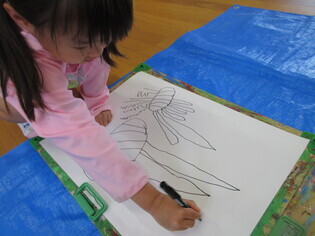 玉ねぎの絵を描いている子どもたちの写真