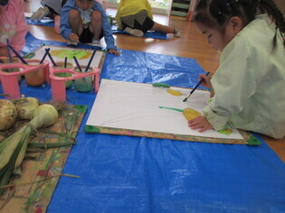 玉ねぎの絵を描いている子どもたちの写真