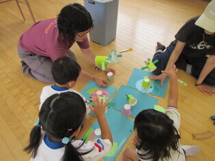 作ったカエルで遊んでいる子どもたちの写真