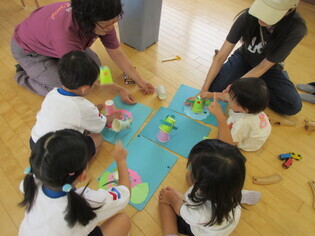 作ったカエルで遊んでいる子どもたちの写真