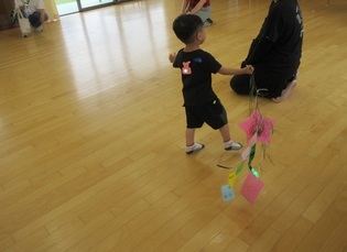 作った七夕飾りを持って遊んでいる子どもの写真