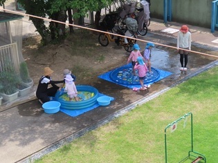 水遊びをしているくまさんクラブの子どもたちの写真