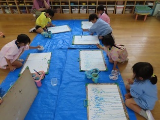 雨の絵を描いている子どもたちの写真