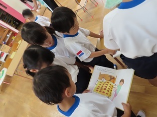 カブトムシの絵本を見ている子どもたちの写真