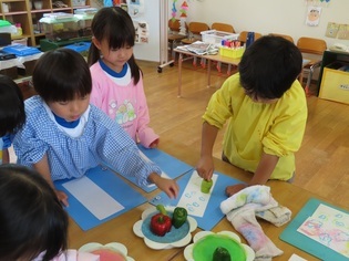 野菜スタンプをしている子どもたちの写真