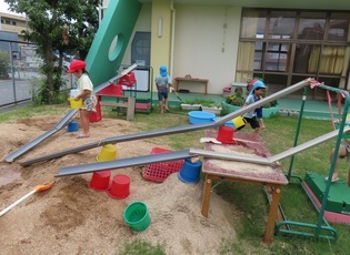 ウォータースライダーを作って遊んでいる子どもたちの写真