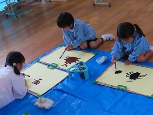 カブトムシの絵を描いている子どもたちの写真
